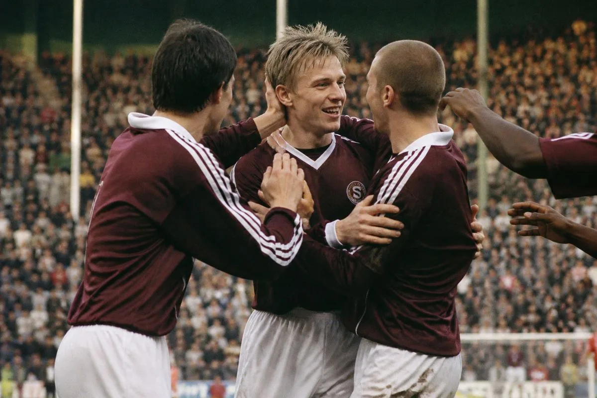 Fletcher Boyd celebrating his goal with teammates on the pitch