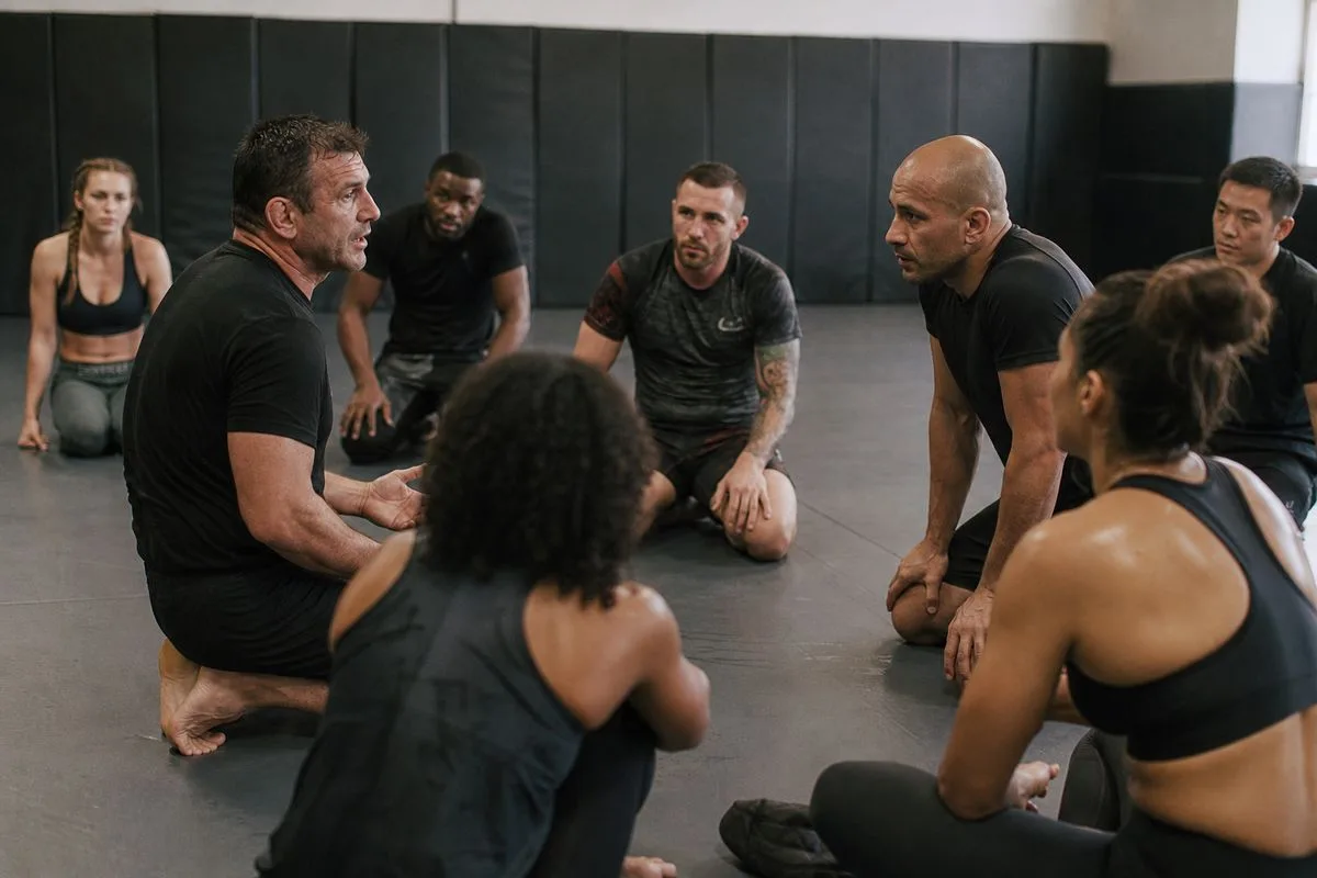 Coaches instructing attentive mixed martial arts students in gym