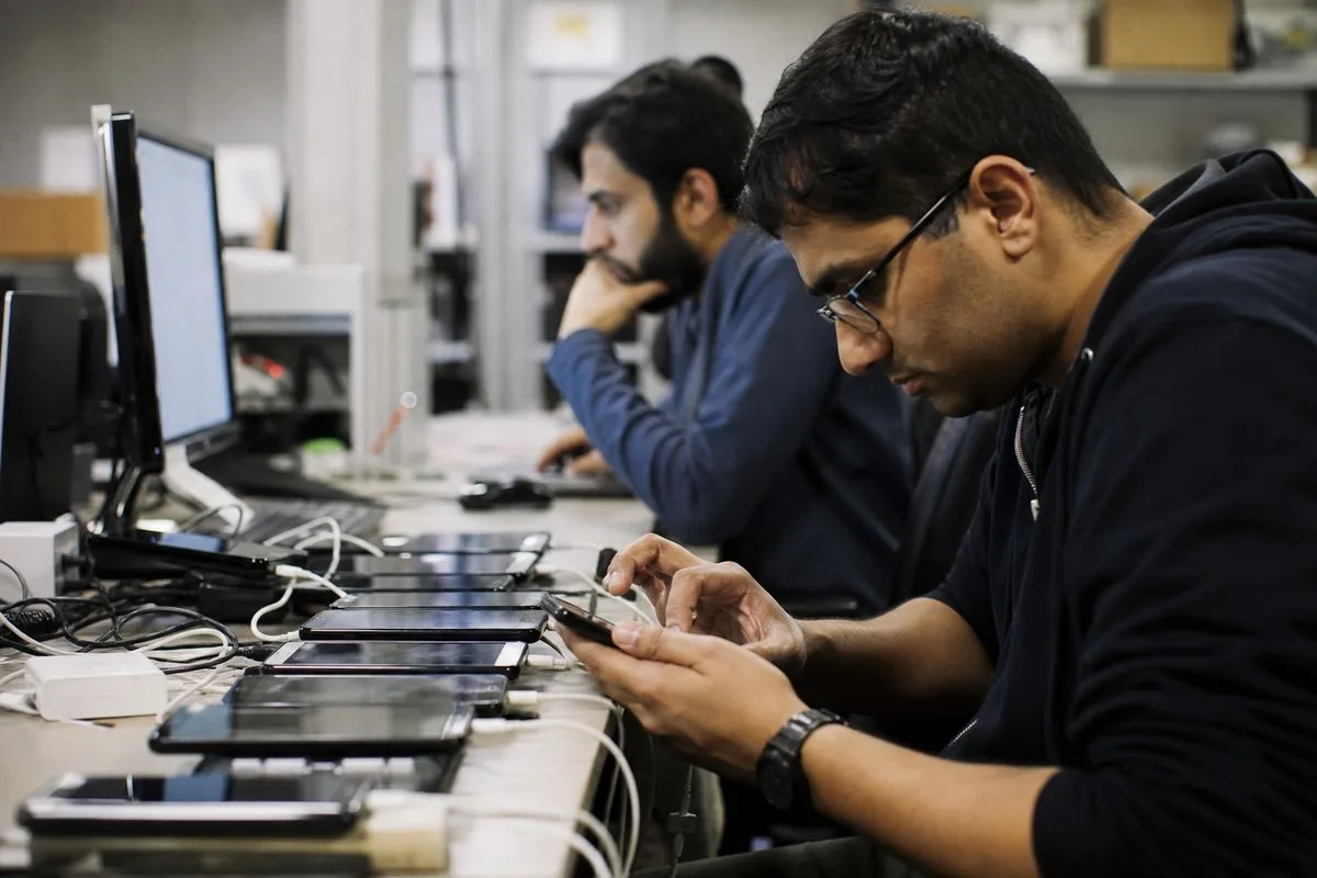 Engineers debugging code on multiple Android devices in a lab