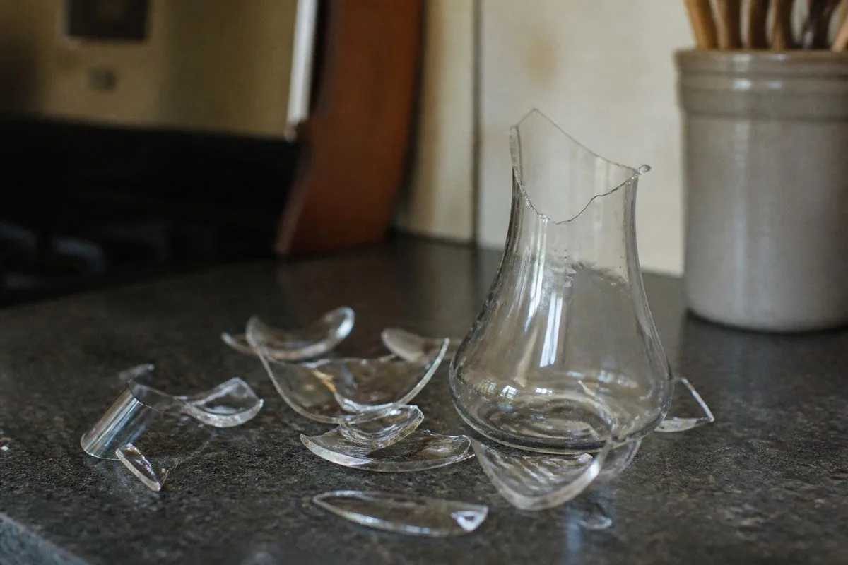 A shattered glass carafe on a kitchen countertop