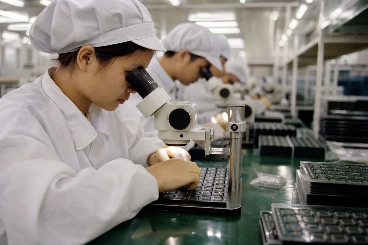 Workers inspecting memory chips at a semiconductor factory