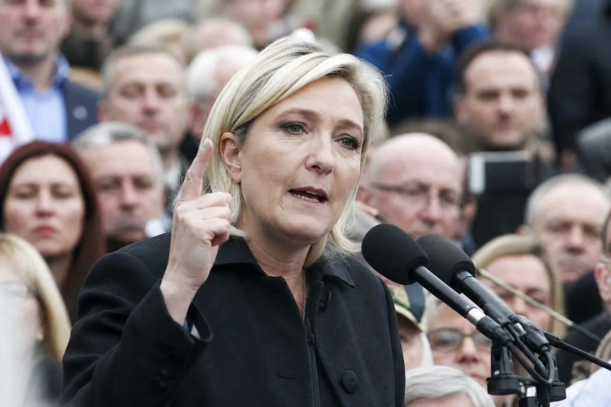 Marine Le Pen speaking at a crowded political rally outdoors
