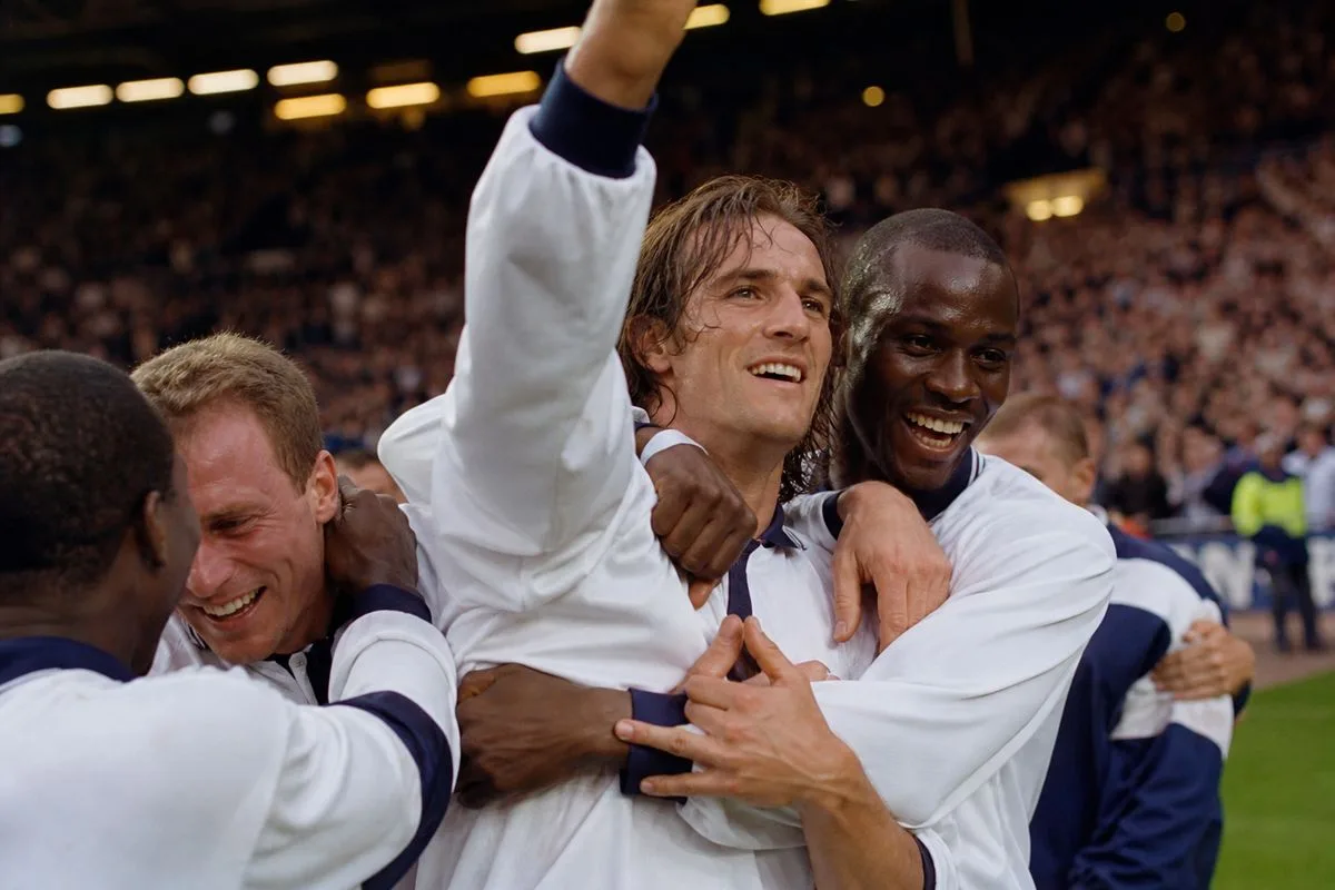 David Ginola celebrating with Spurs teammates in 1999 League Cup win.