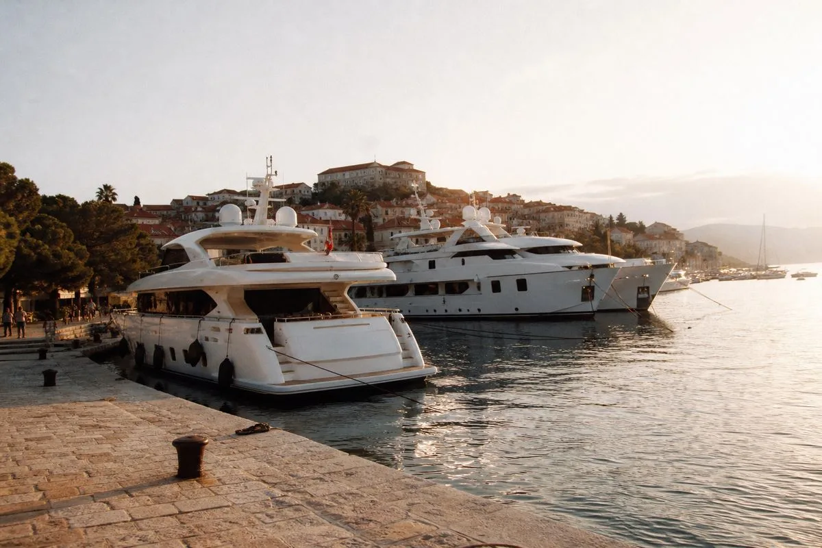 Luxury yachts docked along the Adriatic coastline at sunset