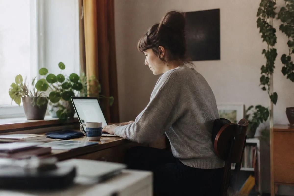 A person working on a laptop in a cozy home office.