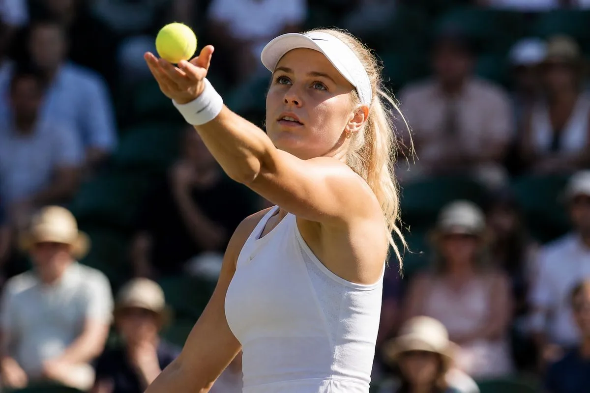 Katie Boulter preparing to serve during a tennis match.