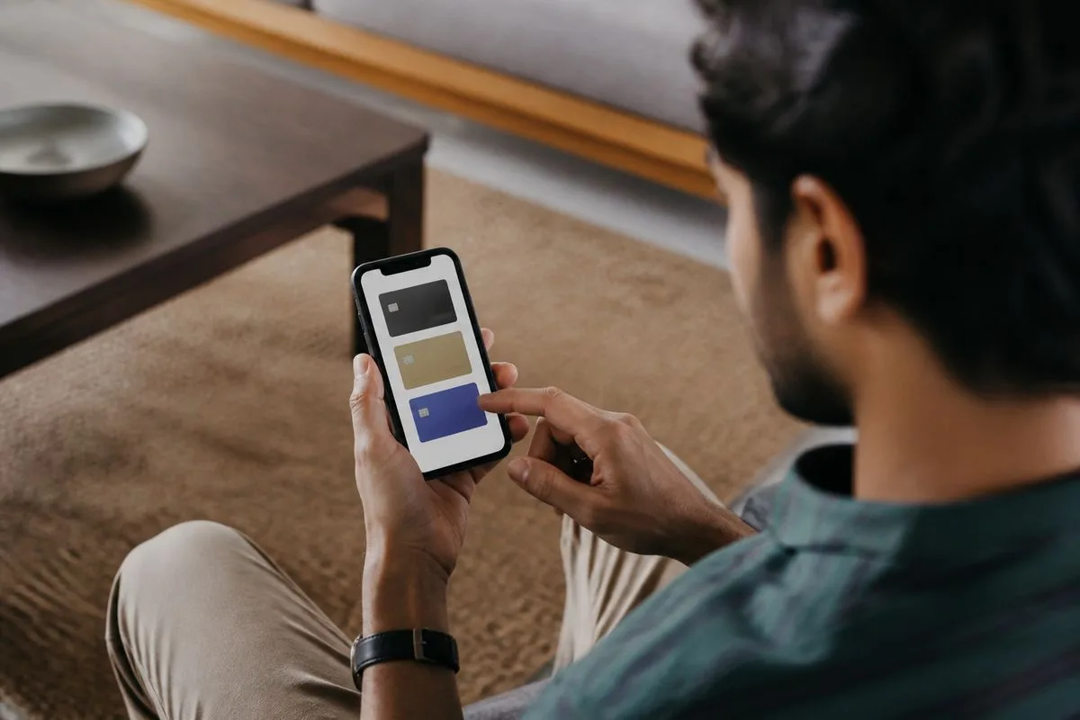 A person using a smartphone to compare cashback credit cards