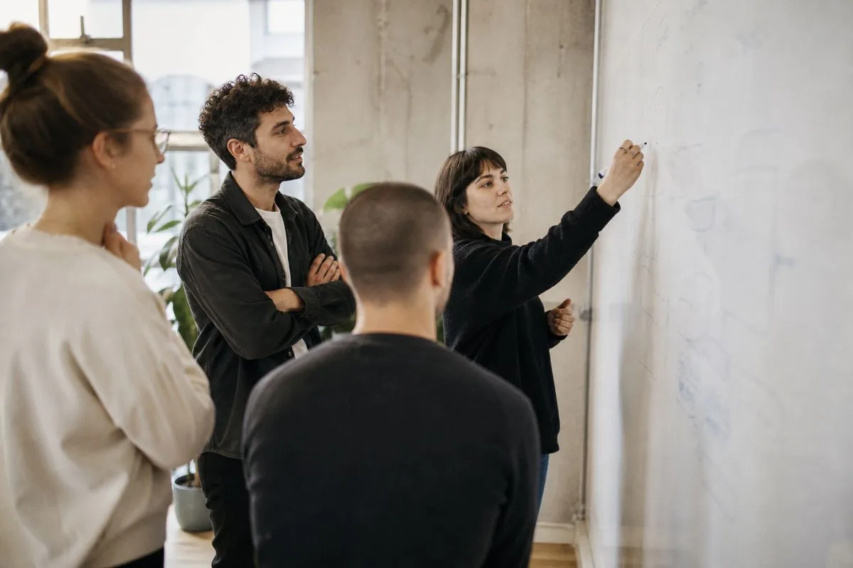 A startup team brainstorming around a whiteboard in an office