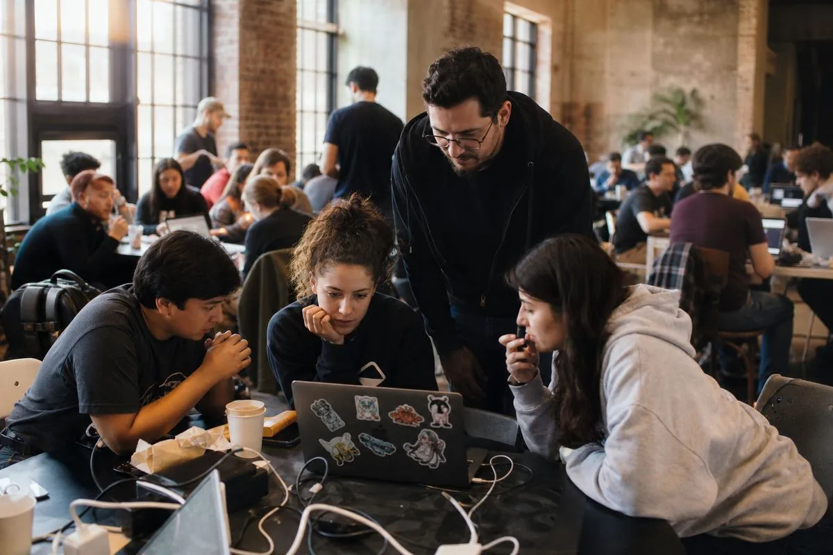 Tech professionals collaborating at a busy hackathon event