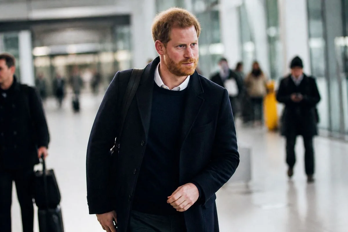 Prince Harry arriving at a London airport terminal.