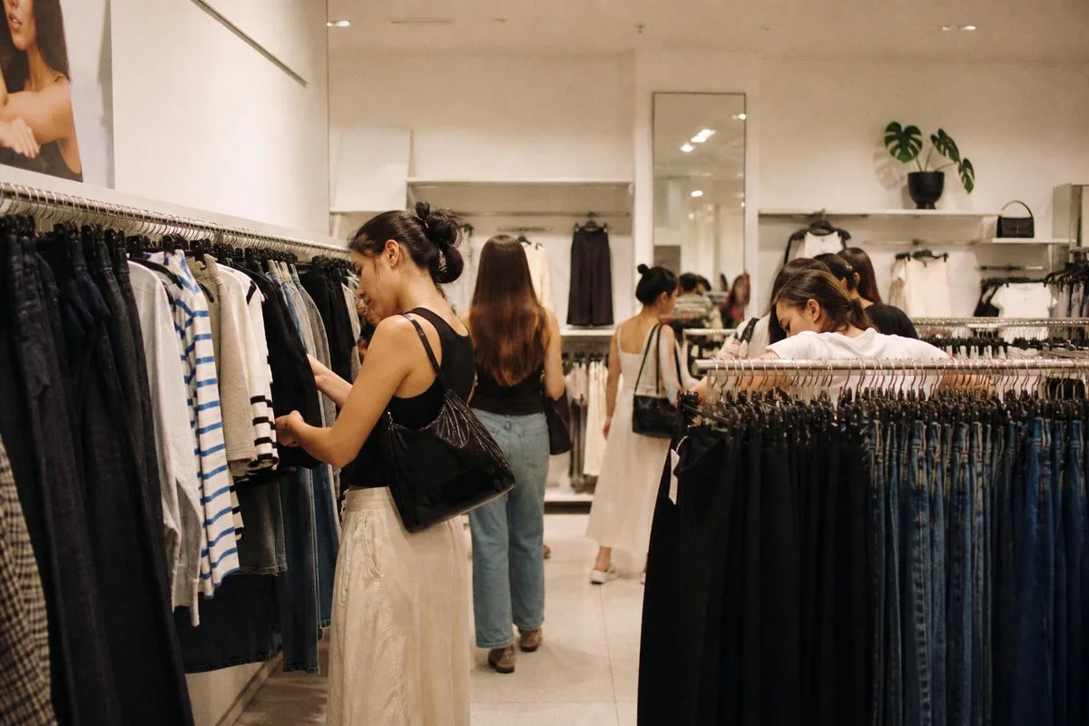 Shoppers browsing a small, modern H&M store interior
