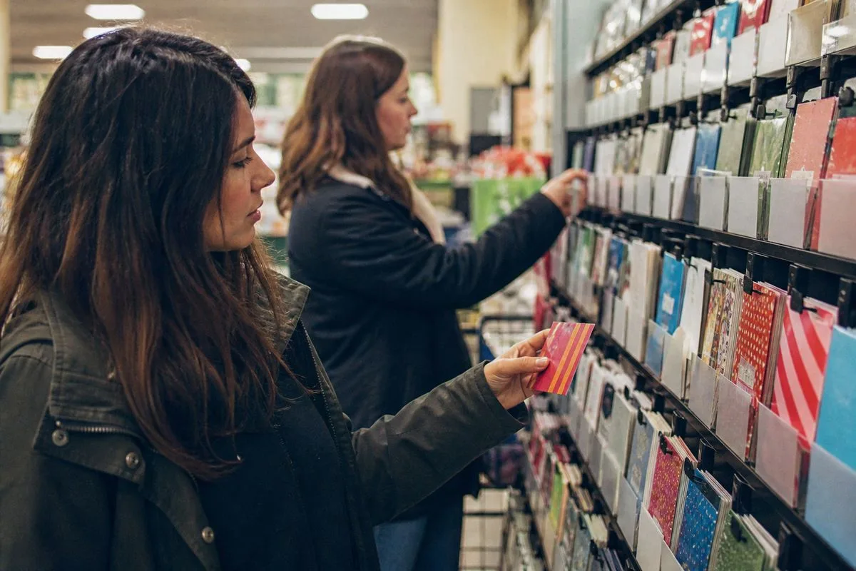Customers browsing gift card displays in a retail store