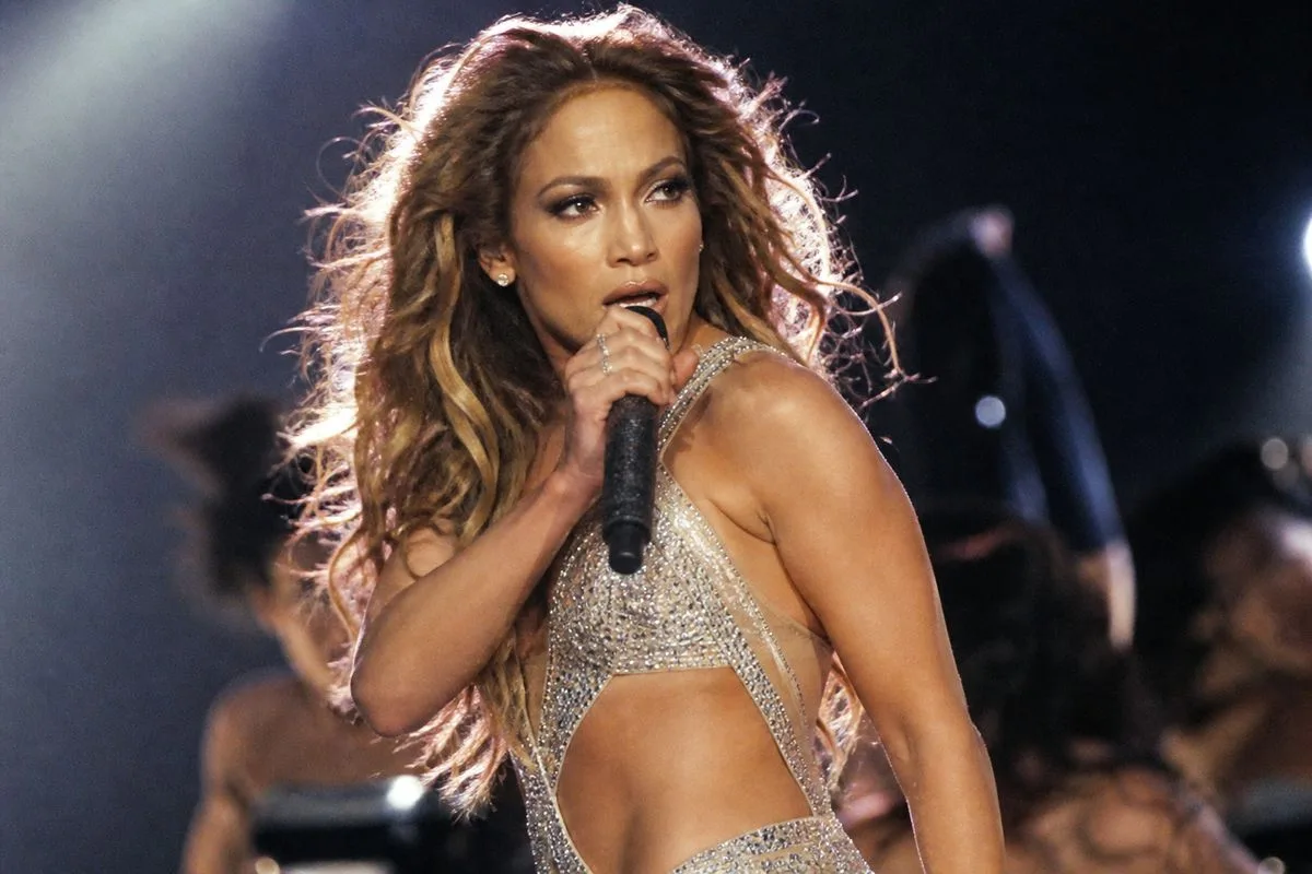 Jennifer Lopez performing confidently on stage, mid-song.