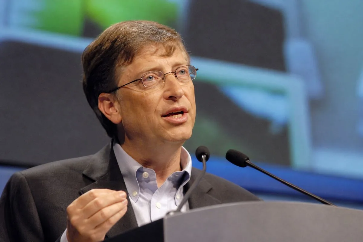 Bill Gates speaking at a technology conference podium