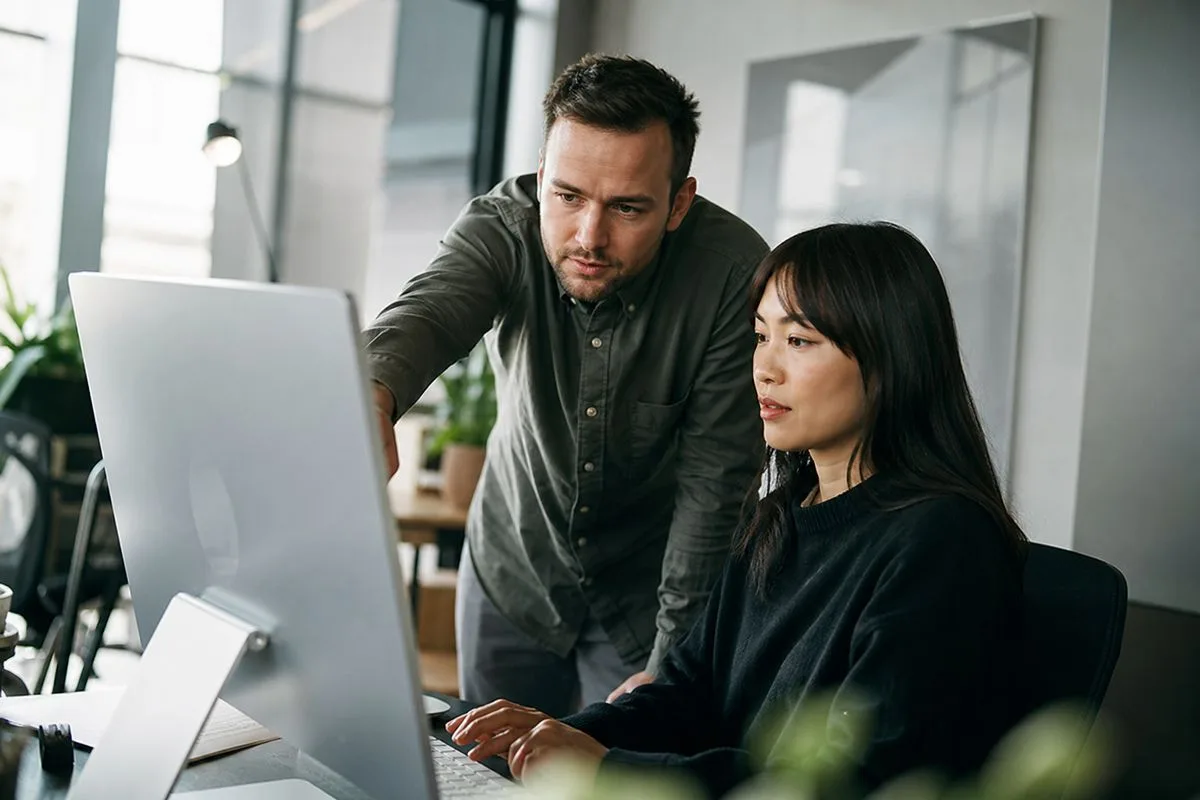 Employees adjusting privacy settings on a modern office computer