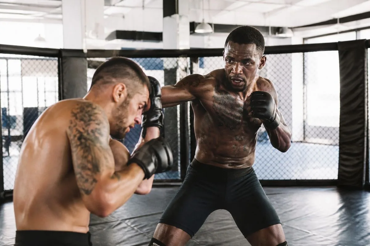 Athletes sparring intensely in a modern MMA gym.
