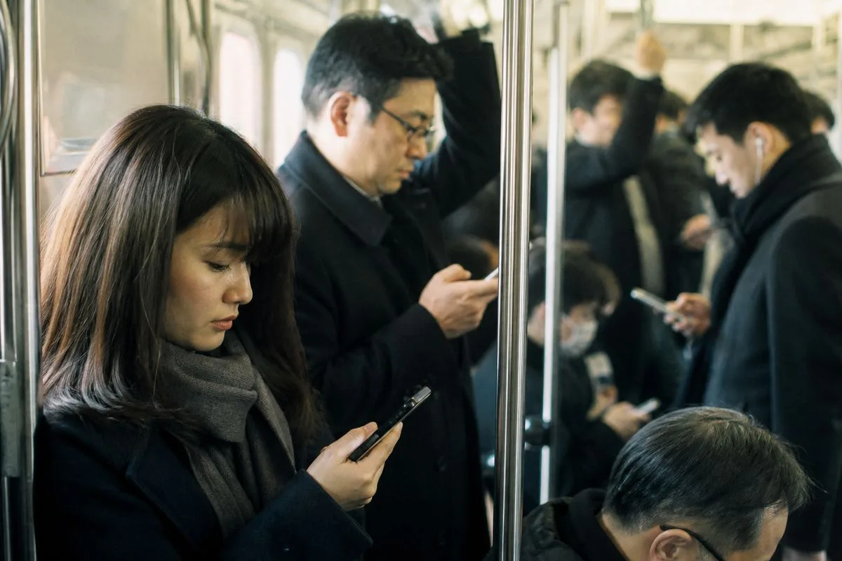 Commuters reading news on their smartphones during a morning rush hour