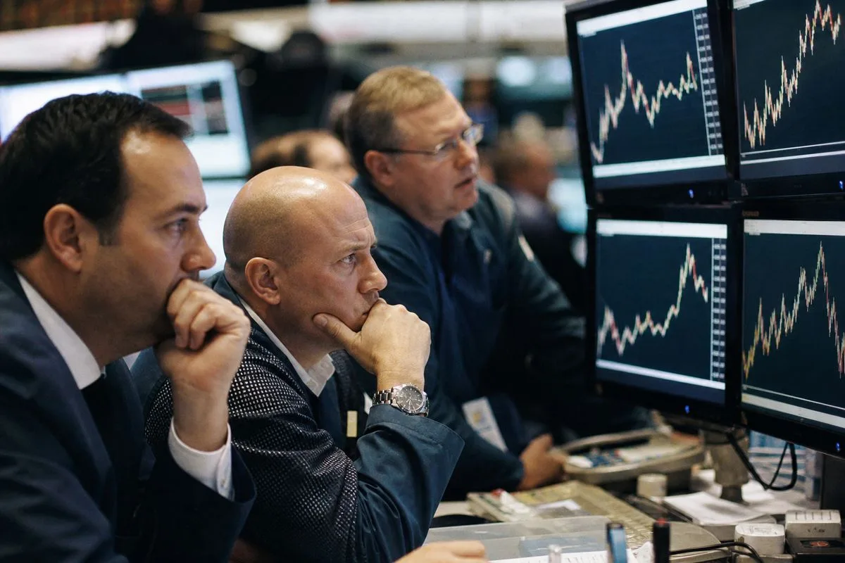 Traders intensely watching precious metals prices on multiple screens.