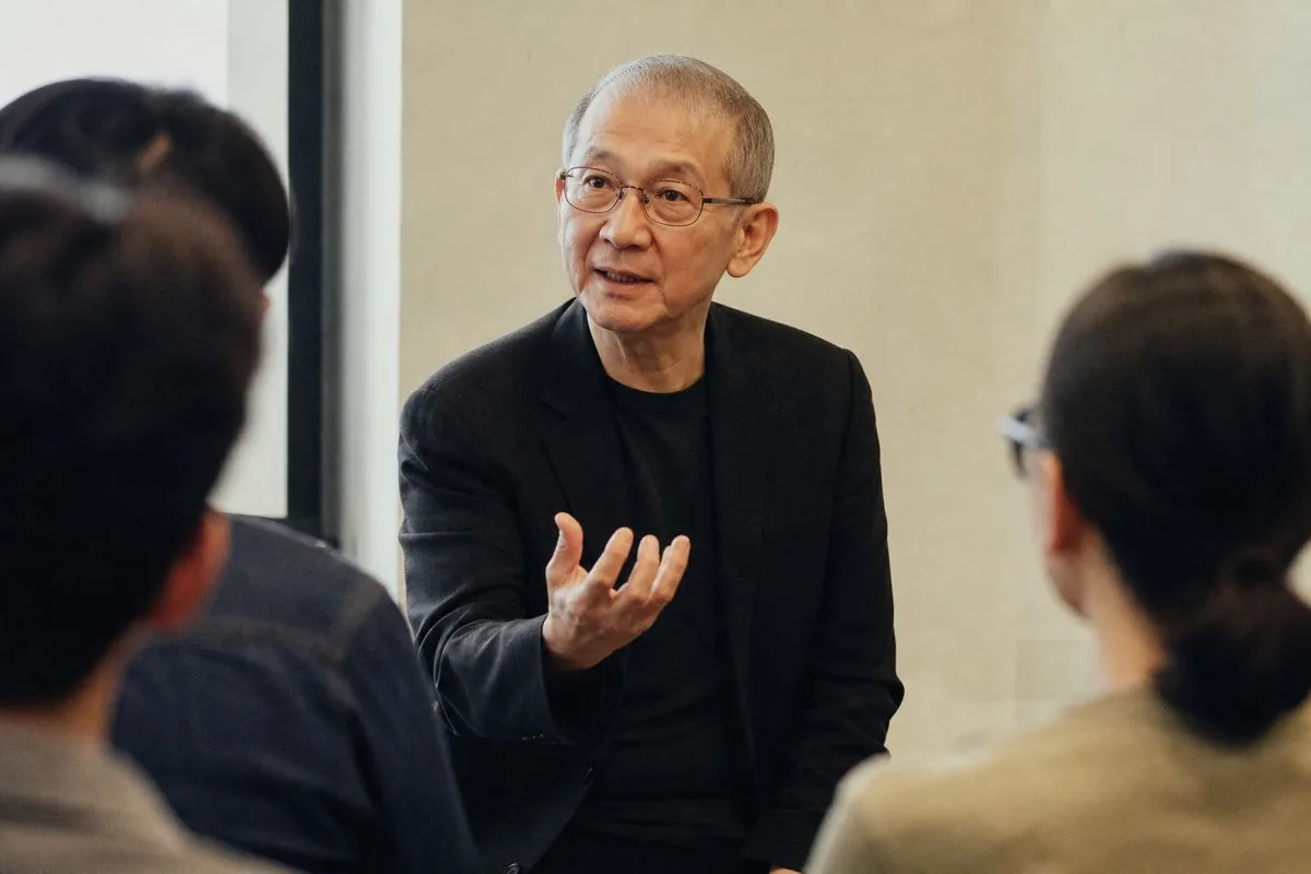 Ricky Lee speaking to a small group in a modern classroom.