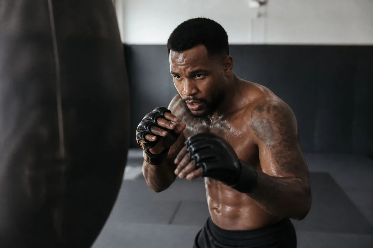 A mixed martial artist training intensely in a gym.
