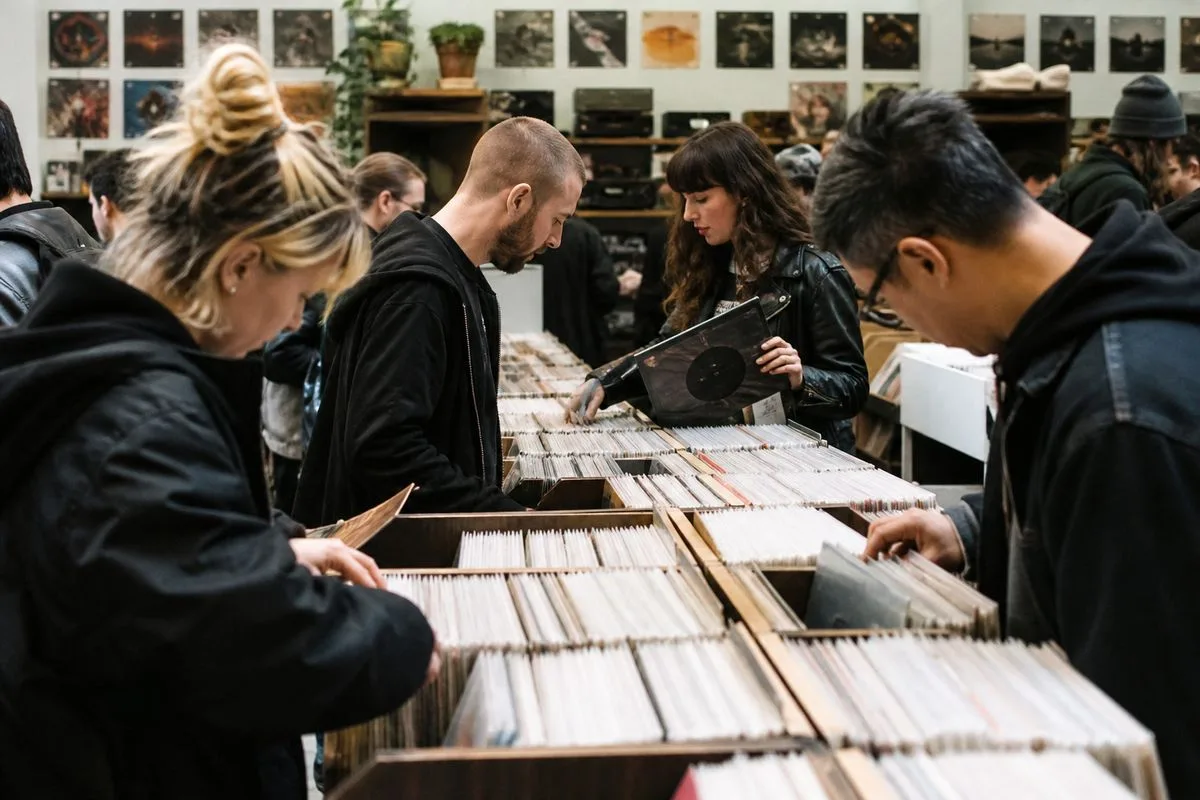 Fans gathered at a vinyl record store browsing albums together