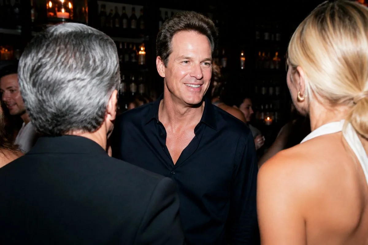 Rande Gerber greeting guests at a stylish bar event