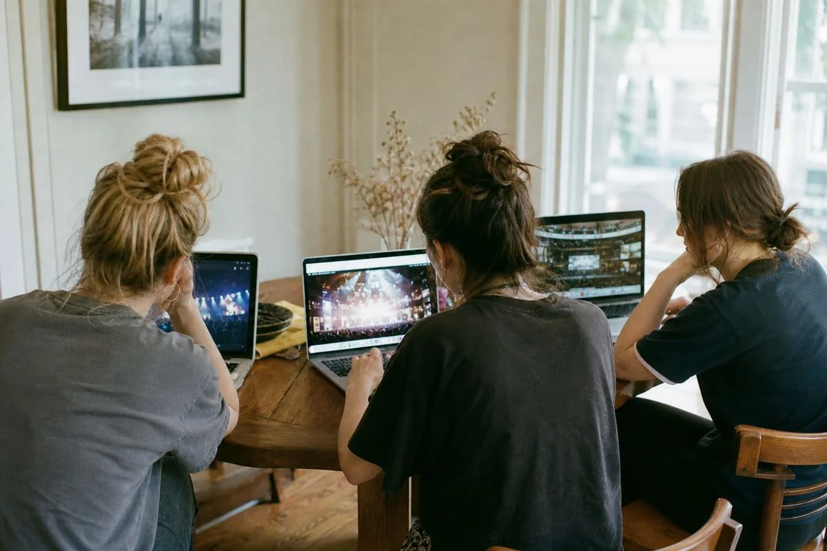Fans browsing multiple concert venue websites on laptops