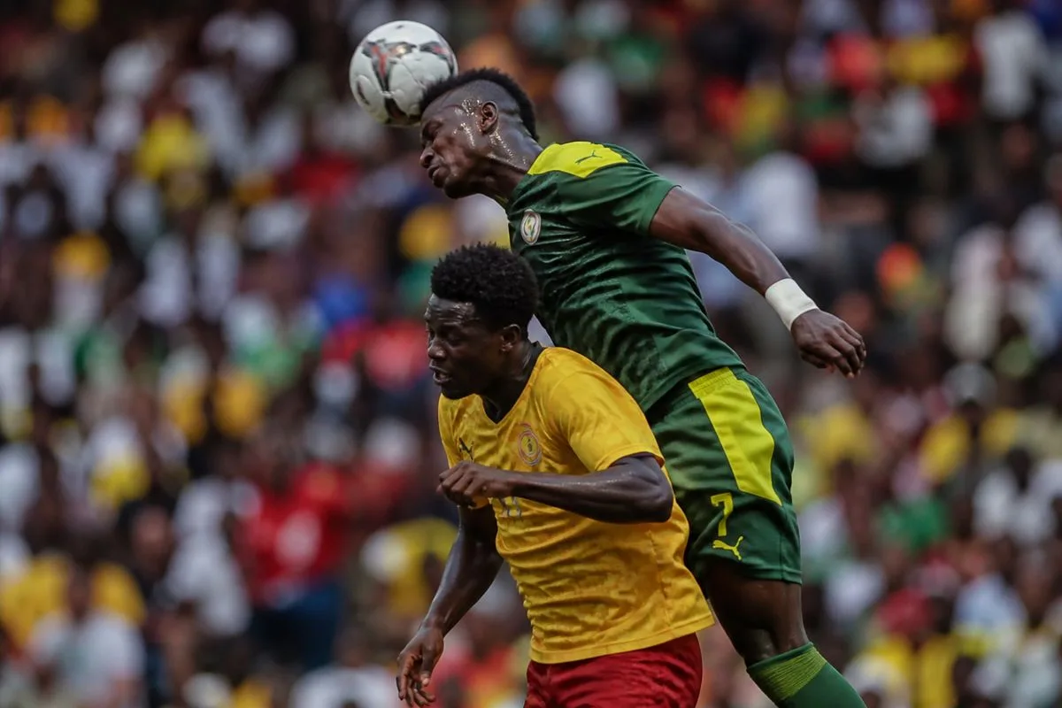 Ethiopian and Senegalese players contesting a header during a tense match.
