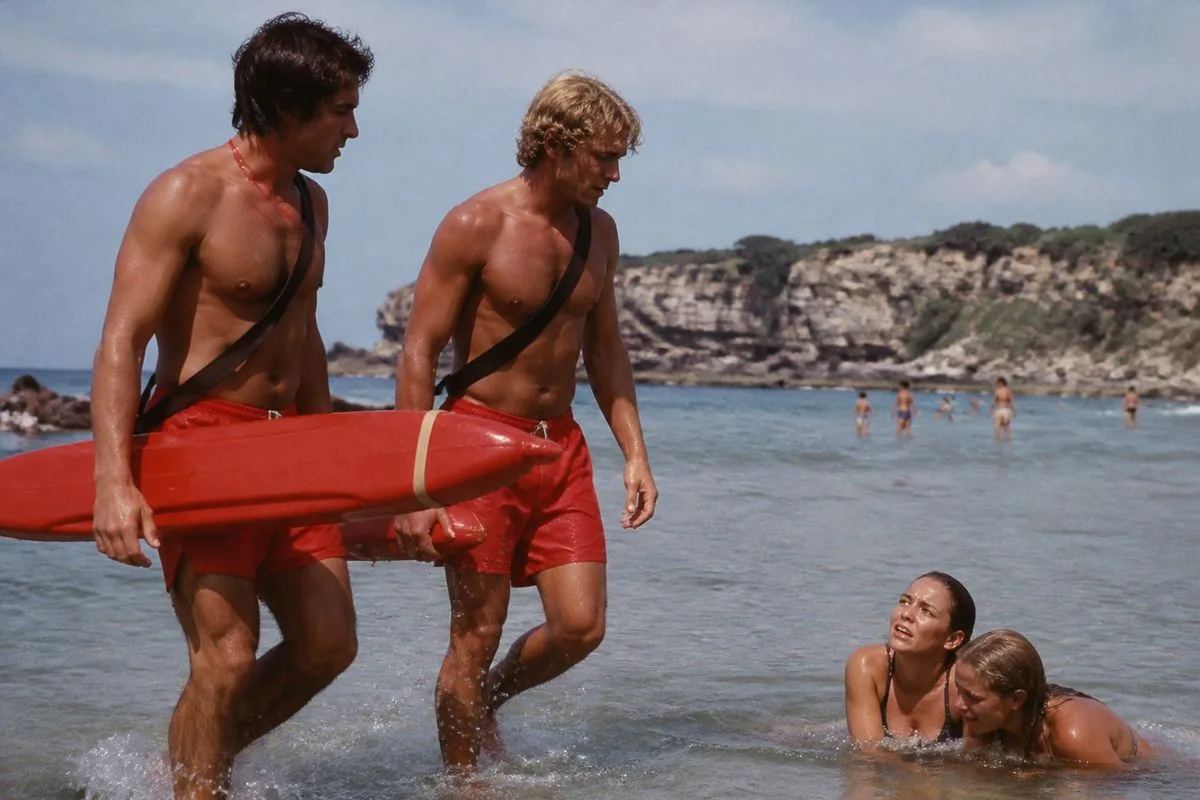 Lifeguards assisting swimmers near a calm beach shoreline