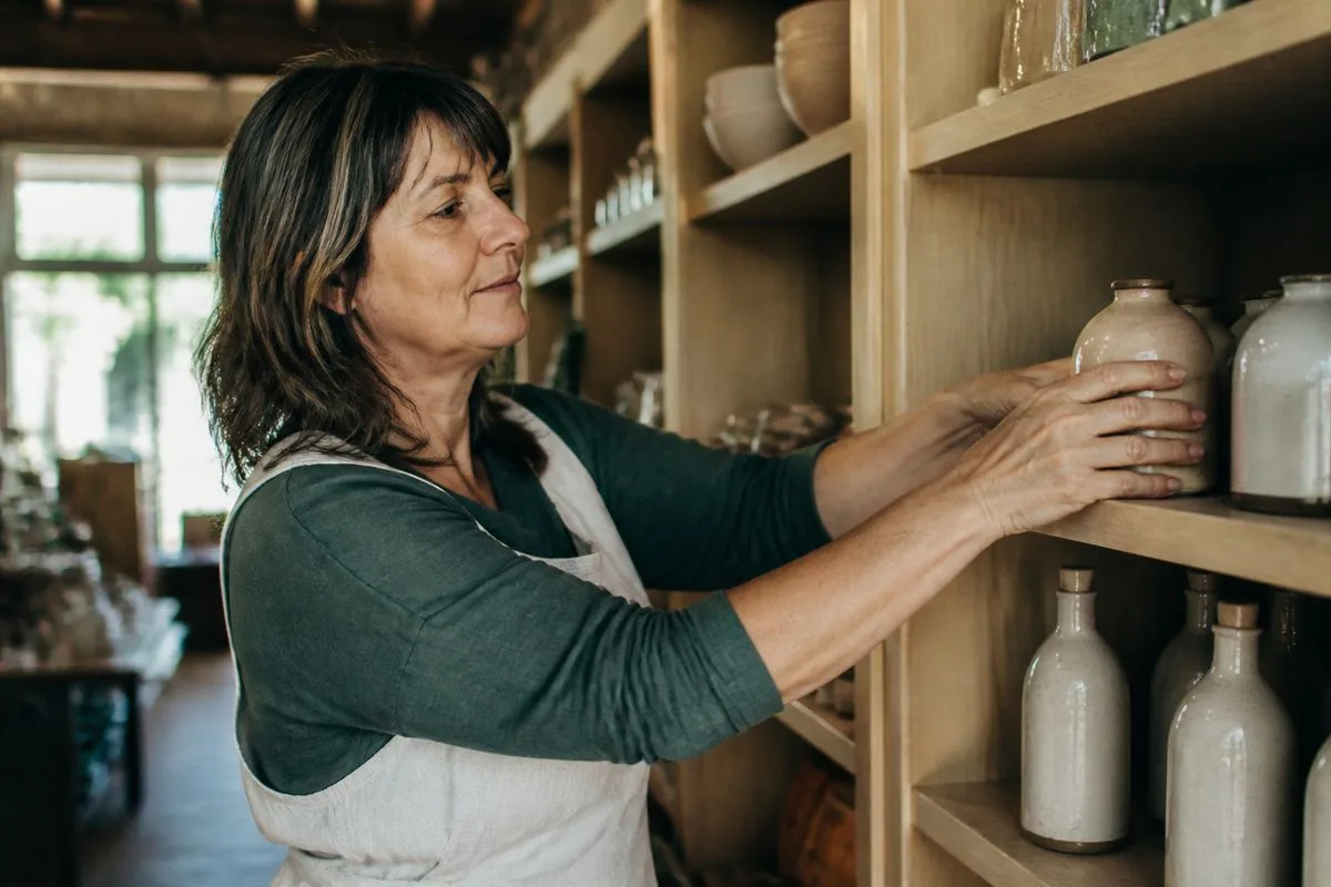 A small shop owner arranging products on shelves