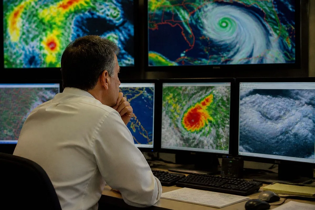 A meteorologist analyzing weather data on multiple screens