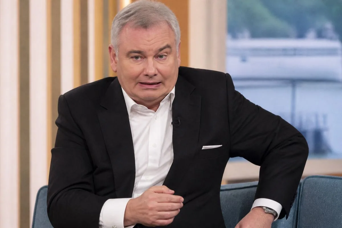 Eamonn Holmes sitting awkwardly on a studio chair during a live broadcast