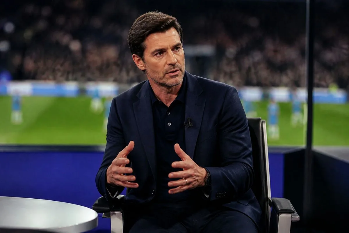 A football pundit analyzing a match in a studio.