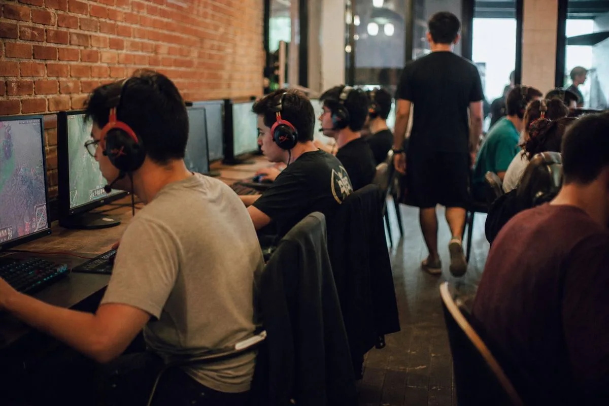 Players gathered in a lively gaming café, focused on screens