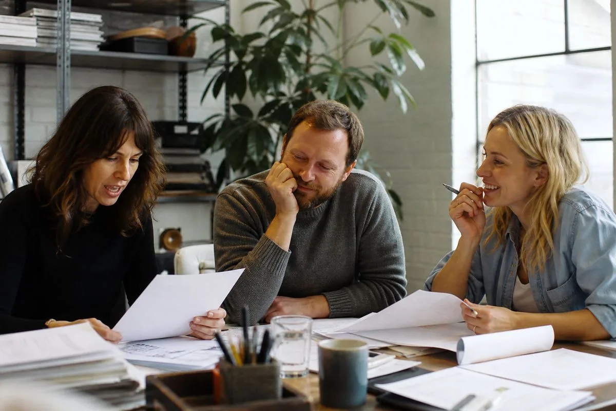 Comedy producers reviewing scripts in a bright studio office