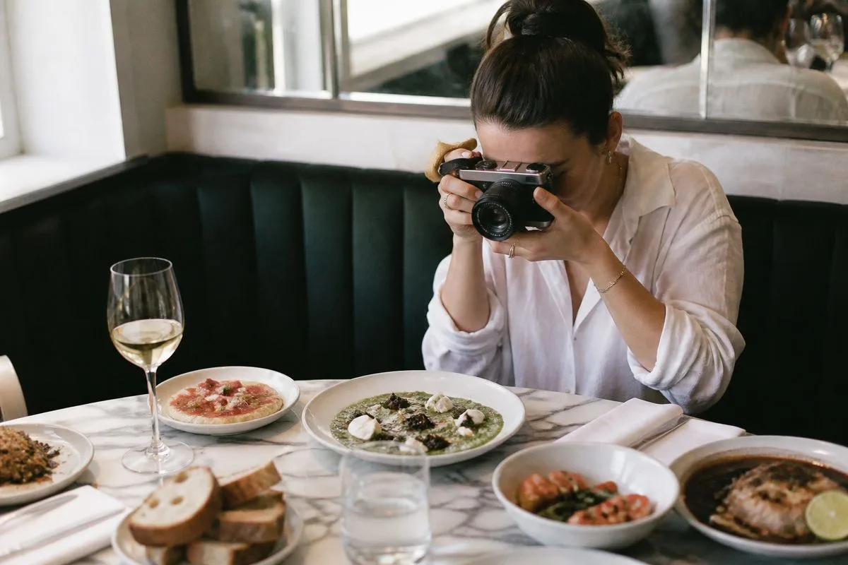 A food blogger photographing dishes at a London restaurant table