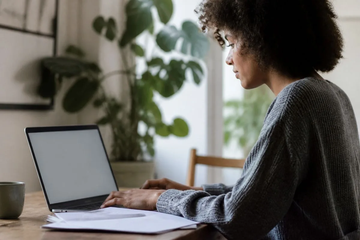 A job seeker updating their resume on a laptop.