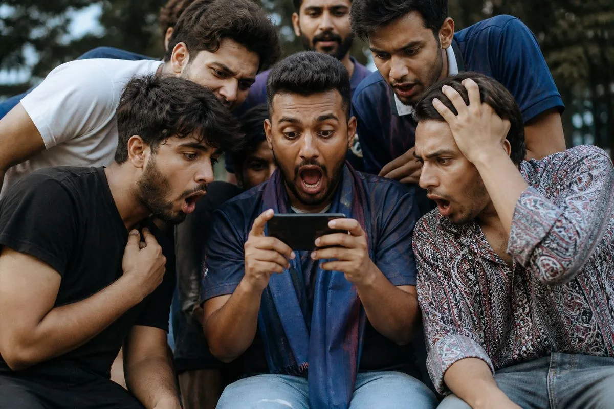 Fans eagerly watching player price reveals on their phones.
