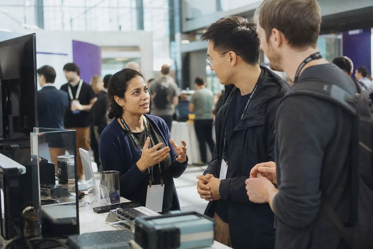 Researchers and engineers collaborating at a tech conference booth