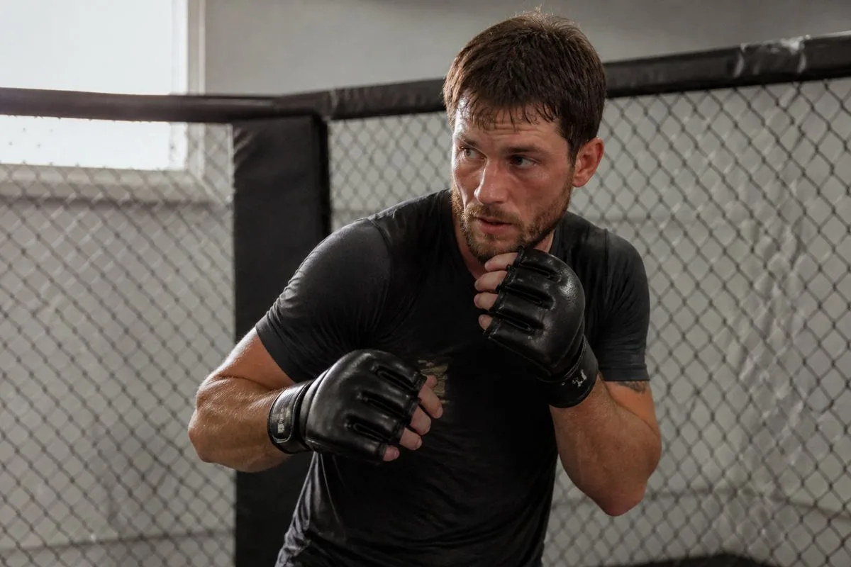 A mixed martial arts fighter training inside a gym cage