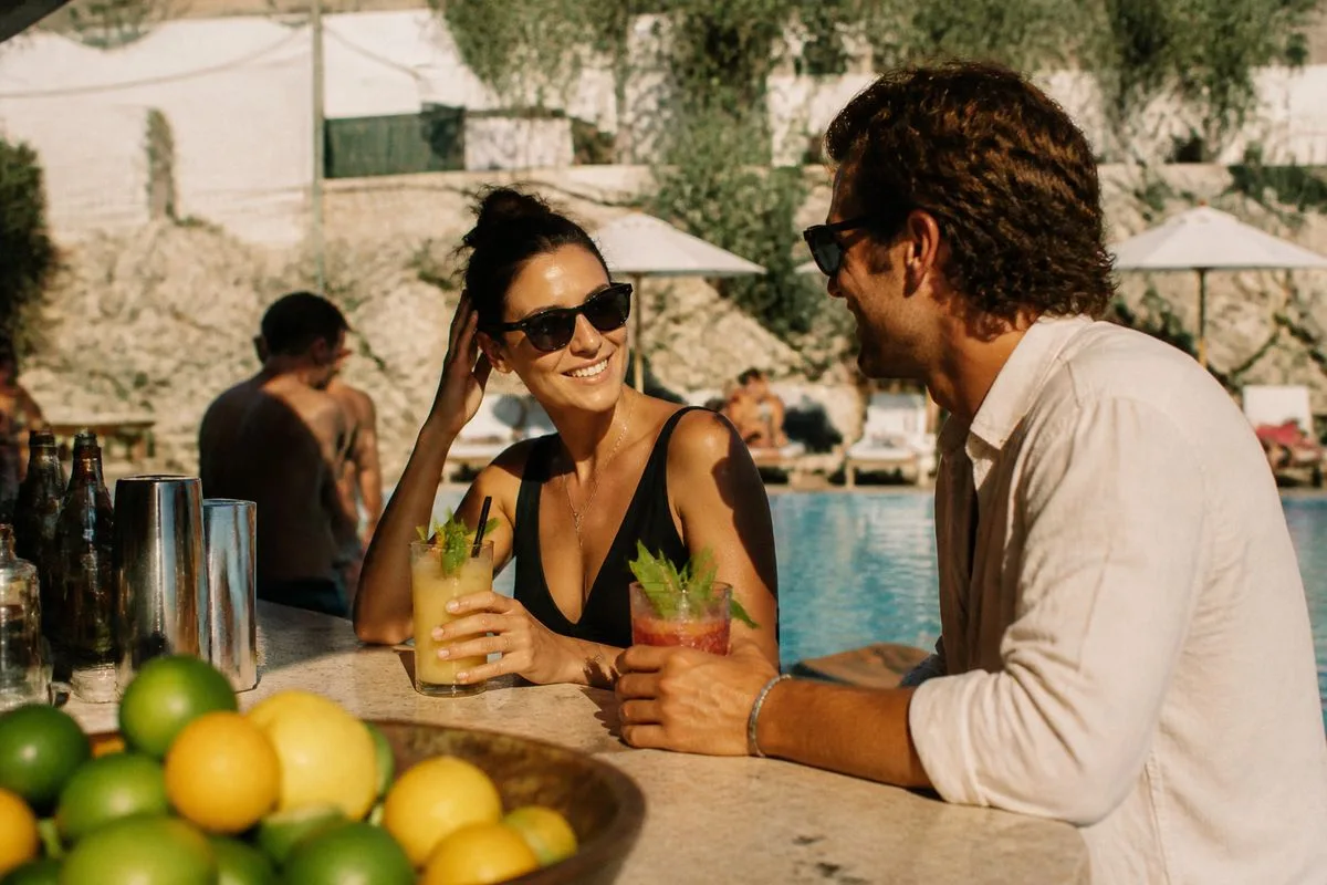 Guests enjoying cocktails by a hotel poolside bar
