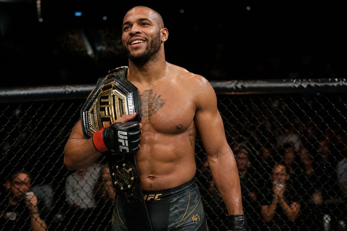 Ciryl Gane holding the UFC championship belt in the octagon.