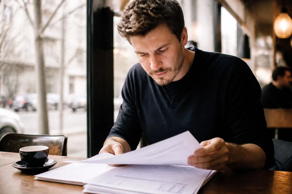 A founder reviewing financial documents at a café table