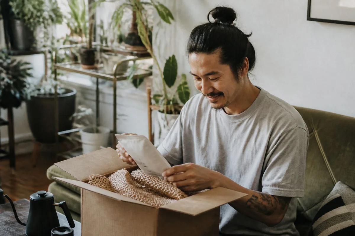 A person unboxing a coffee subscription welcome gift at home