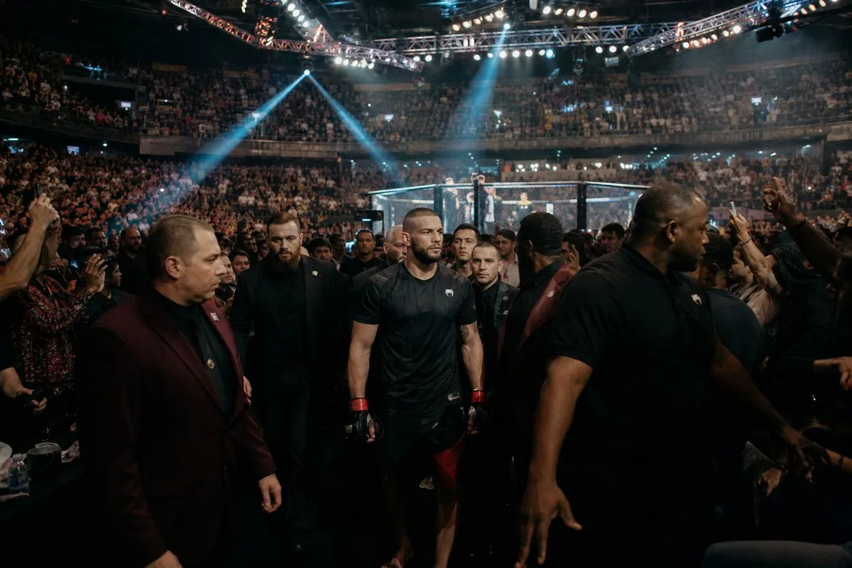 A packed UFC arena with fighters entering the octagon