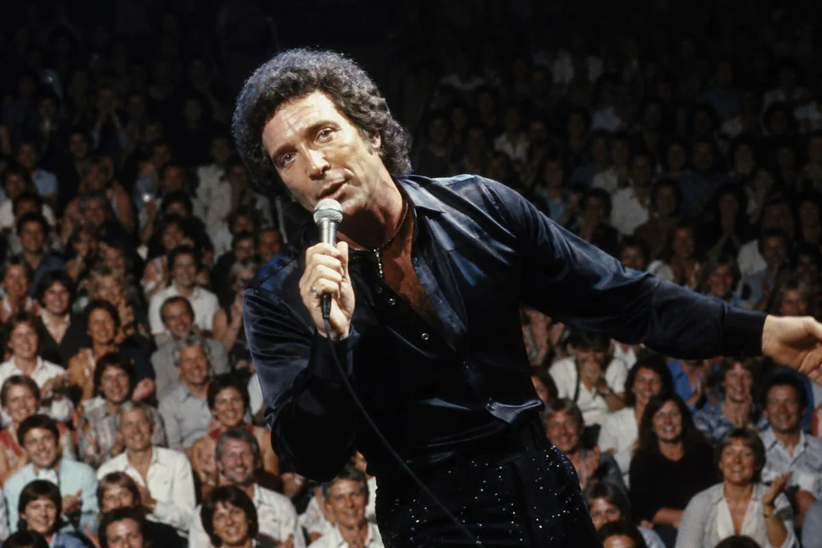 Tom Jones performing on stage with a lively audience