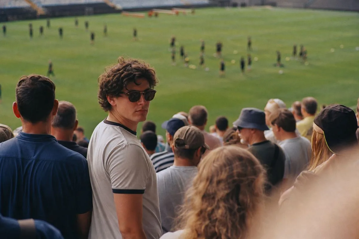Fans gathered at a stadium during pre-season football training.