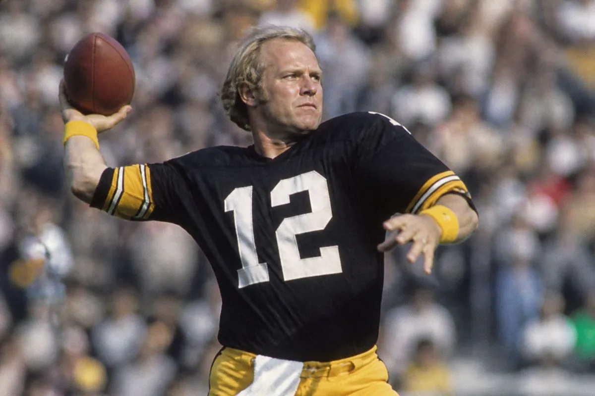 Terry Bradshaw throwing a football during a game.
