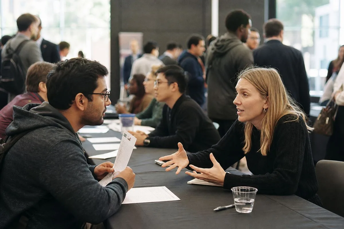 Recruiters and candidates discussing opportunities at a tech job fair