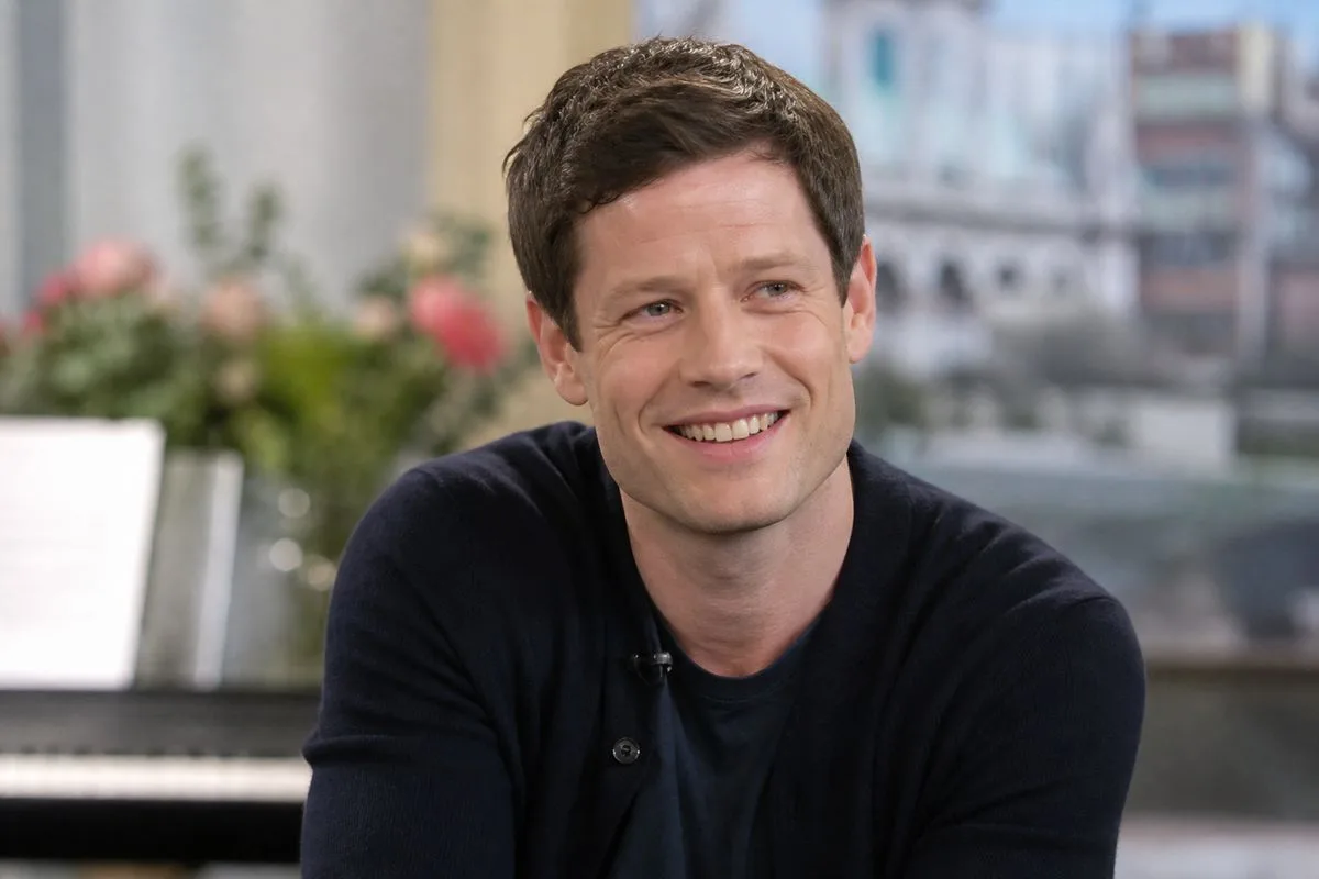 James Norton smiling during a TV interview on set